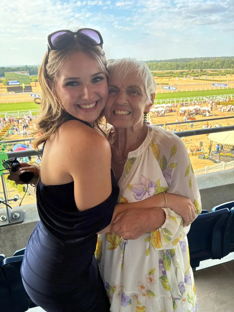 Two guests share a hug overlooking the racecourse at Ascot